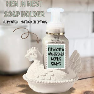 May include: A white hen-shaped soap holder with a soap dispenser. The holder has a detailed design and is 3D printed. The text on the holder says "Fits Bath and Body Works Soaps."