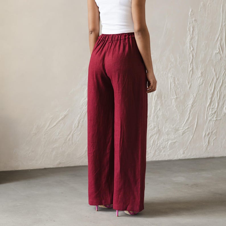 May include: Wide-leg pants in a deep burgundy color. The pants have a relaxed fit and a high waist.