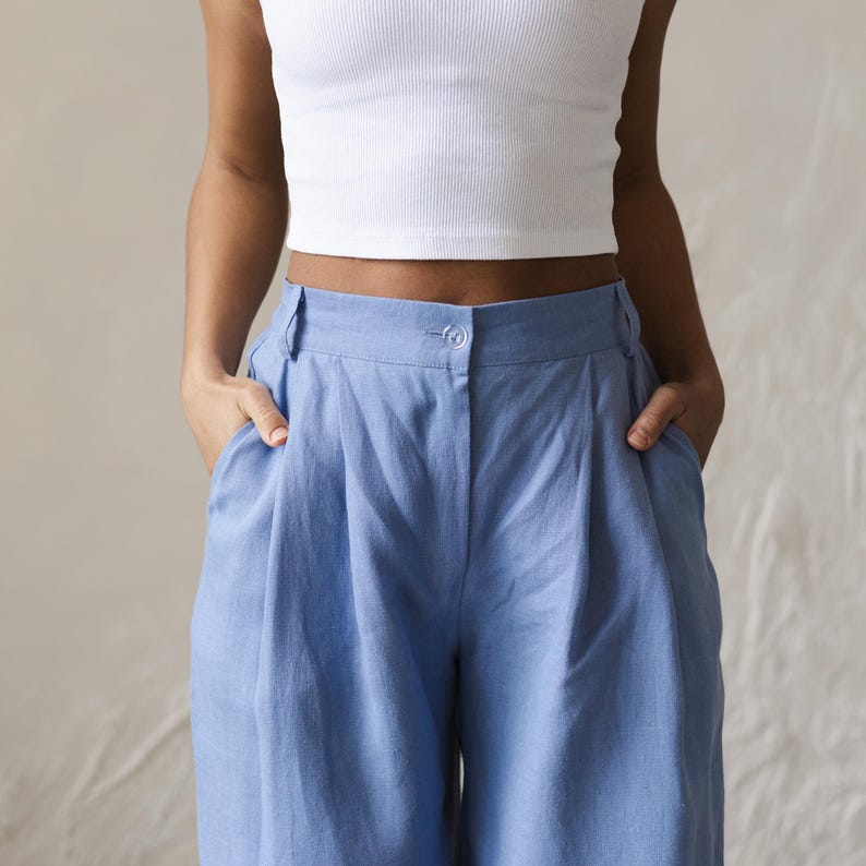 May include: A pair of light blue high-waisted pants with pleats and pockets.