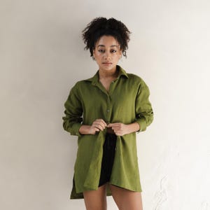 May include: A long-sleeved, olive green linen shirt with a collared neckline and button closure. The shirt is loose-fitting and has a relaxed silhouette.
