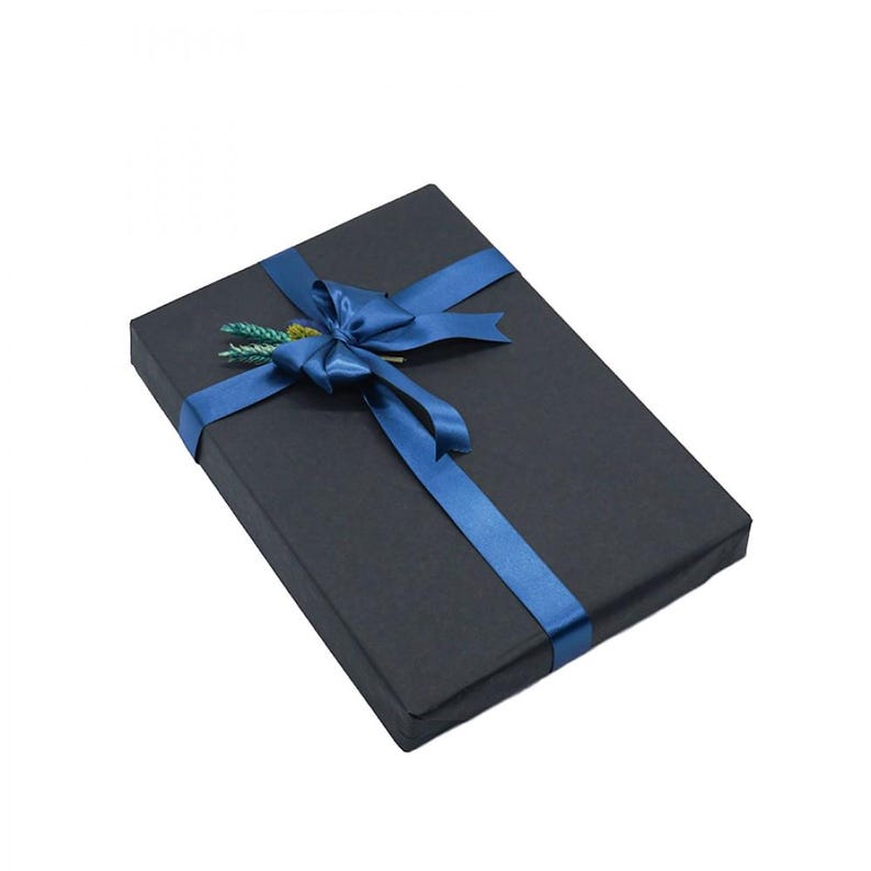 May include: A rectangular gift box wrapped in black paper, adorned with a vibrant blue satin ribbon tied in a bow. A small sprig of greenery adds a touch of natural detail to the presentation.