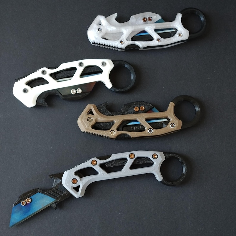 May include: Four different styles of pocket knives with black handles and various colored blades. The knives have a unique design with a ring on the handle.