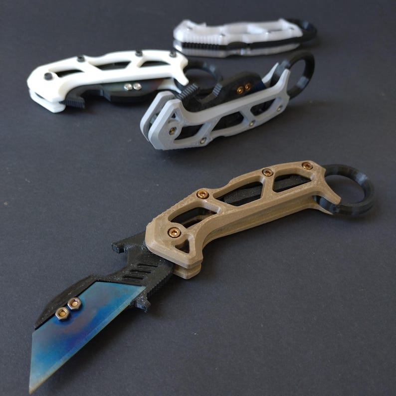 May include: Three different styles of pocket knives with a black, white, and tan colored handle. The knives have a unique design with a skeletonized handle and a blade that is partially exposed.
