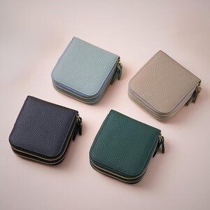 A palette of four pebble leather jewelry cases in blue, green, gray, and black, demonstrating a cohesive minimalist aesthetic