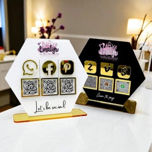 May include: Two hexagonal social media displays, one white and one black, with gold-coloured icons and QR codes. The white display has the text "Let's be social." The black display has the text "Scan to pay."