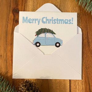 Carte de Noël / Fêtes / Hiver - Dites « Joyeux Noël » cette saison avec cette jolie voiture bleue portant un arbre au sommet. Individuel ou lot