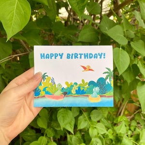 Dinosaur Birthday Card - Cute hand drawn card with baby dinos boating and tubing - Colourful illustrated tropical scene for a special day