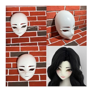 May include: Four images of white masks with stylized facial features. The masks have cut-out eye and mouth shapes. One image shows a mask with a black wig and painted face. The masks are displayed against a red brick wall.
