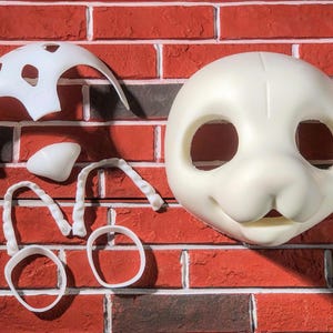 May include: White plastic mask and parts for a furry costume. The mask has two eye holes and a nose. The parts include a headpiece, nose, and two ear pieces.