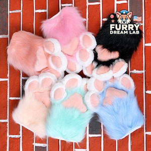 May include: Six pairs of furry paw hand puppets in various colors, including pink, peach, light blue, turquoise, and black. The puppets have white paw pads and are arranged on a red brick background. The text "FURRY DREAM LAB" is visible in the upper right corner of the image.