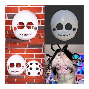 May include: White, oval-shaped masks with large eye holes, small cheek dots, and a jagged mouth design. One mask is shown on a brick wall, another on a gray background, and a third mask is shown with a dotted top.