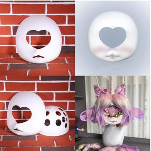 May include: A collection of white, blank doll faces and a finished unicorn doll. The blank faces have heart-shaped eye cutouts and small mouth cutouts. The unicorn doll has purple and pink hair, a horn, and floral accents.