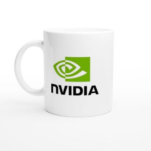 Op de afbeelding: Witte keramische mok met het NVIDIA-logo in groen en zwart. Het logo bevat een gestileerd oogontwerp in een groene vierkant, met het woord "NVIDIA" eronder gedrukt in een vet, zwart lettertype. De mok heeft een gebogen handvat.