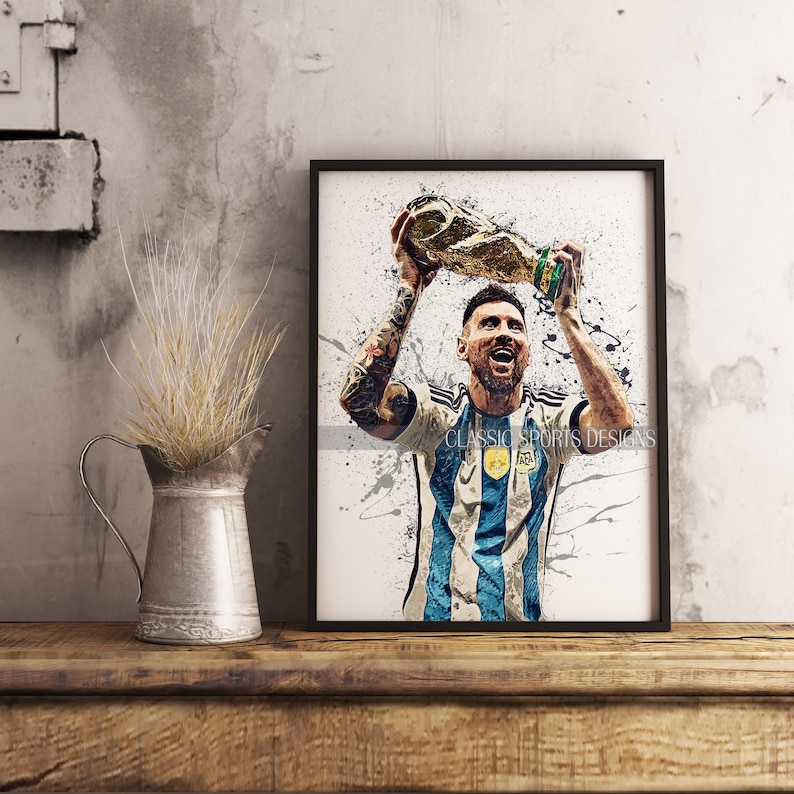 K&ouml;nnte beinhalten: Ein Aquarellbild eines Fu&szlig;ballspielers, der eine goldene Troph&auml;e hochh&auml;lt. Der Spieler tr&auml;gt ein blau-wei&szlig; gestreiftes Trikot mit der Nummer 10. Der Hintergrund ist ein Spritzer aus blauer und wei&szlig;er Farbe.