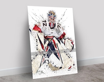 May include: A framed art print of a hockey goalie in a white, red, and blue uniform. The goalie is in a crouched position, with the number 72 visible on the jersey. The artwork has a watercolor effect with paint splatters.
