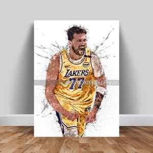 May include: A basketball player wearing a yellow and purple jersey with the word "LAKERS" and the number "77" on the front. The player is in mid-action, with a determined expression on his face. The background is a white splatter pattern.