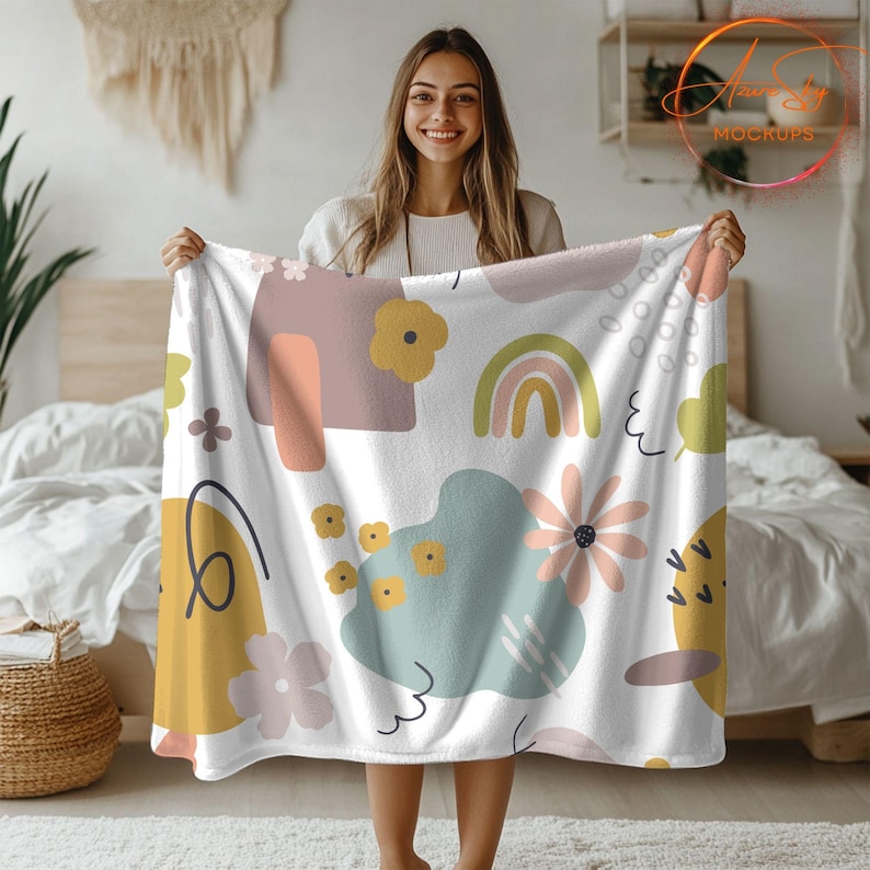 May include: A white fleece throw blanket with a colorful abstract pattern featuring rainbows, flowers, and geometric shapes. The pattern is in shades of pink, yellow, green, and blue.