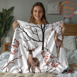 May include: White fleece blanket with a watercolor design of deer and red berries on bare branches.