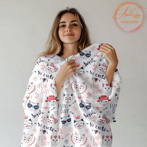 May include: A white blanket with a repeating pattern of pink and blue cats, hearts, and flowers. The text "Smile so cute" and "Fun Day" is repeated throughout the pattern.