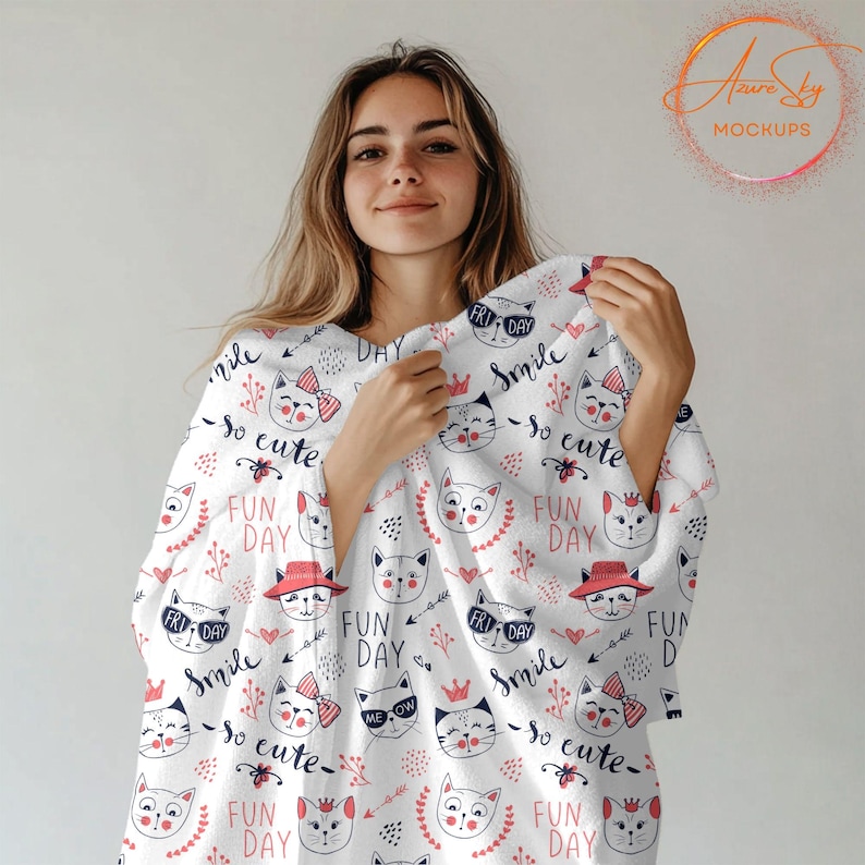 May include: A white blanket with a repeating pattern of pink and blue cats, hearts, and flowers. The text "Smile so cute" and "Fun Day" is repeated throughout the pattern.