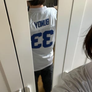 May include: White jersey with blue lettering and the number 33 on the back. The lettering says "Younus".