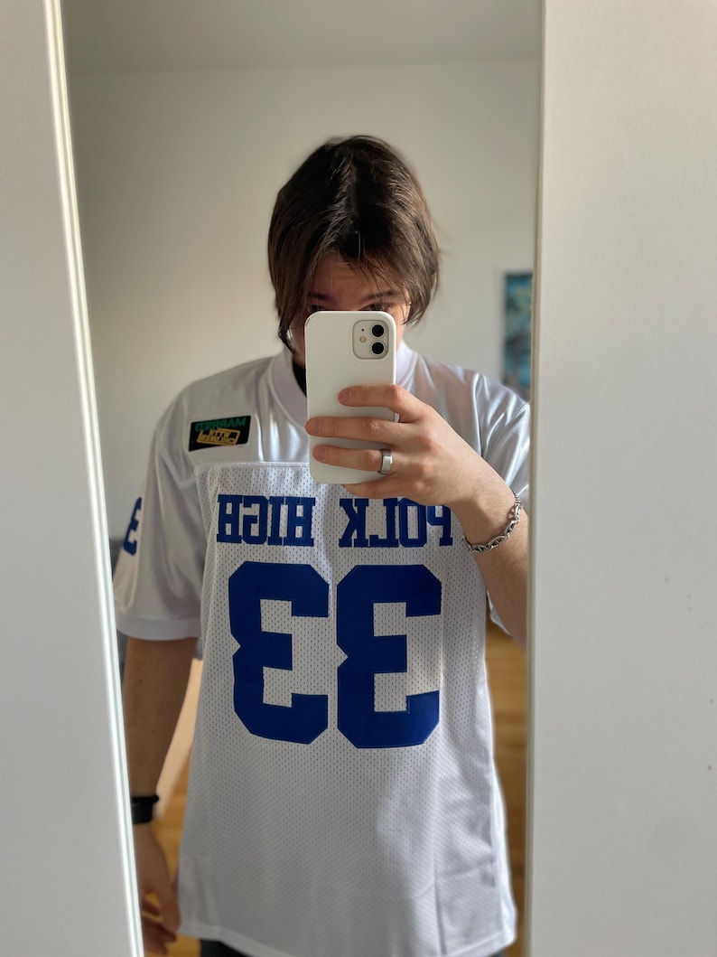 May include: White jersey with blue lettering and a number 33 on the front. The jersey says "Polk High" on the back.