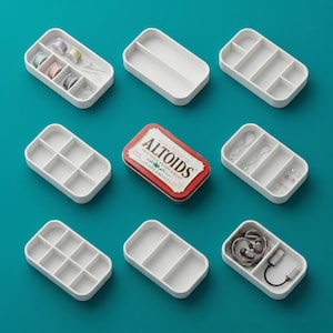 Puede incluir: Una colección de bandejas blancas compartimentadas y una lata de Altoids sobre una superficie turquesa. Las bandejas contienen artículos como suministros de costura, joyas y electrónica. La lata de Altoids es roja y blanca con el texto "Altoids Peppermint".