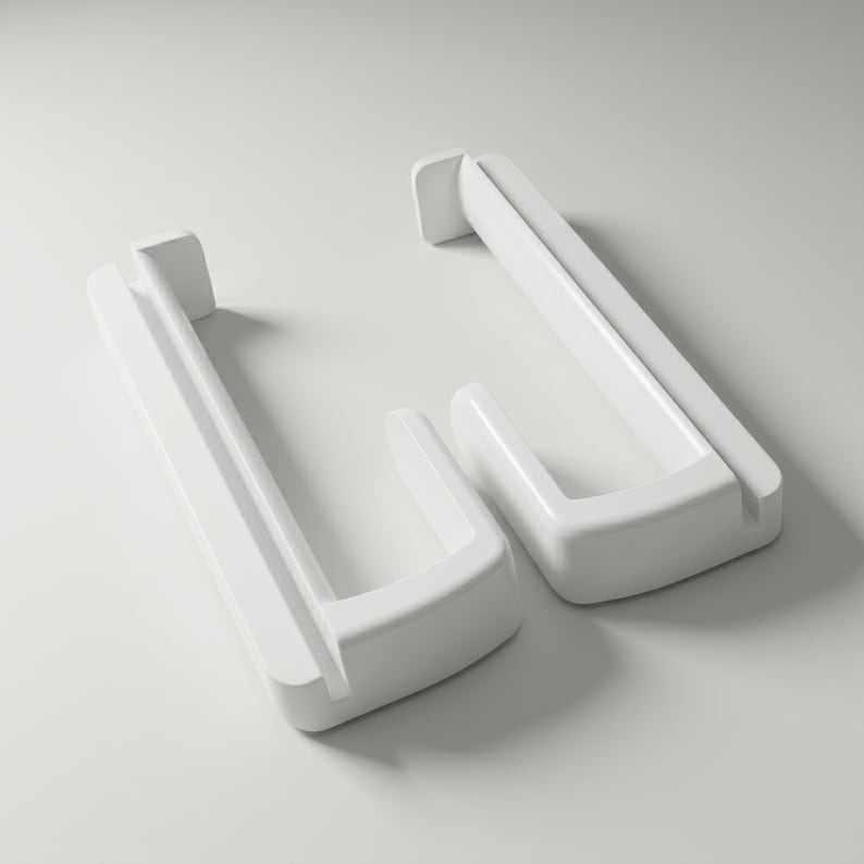 May include: Two white door handles in a modern style. Each handle has a rectangular base with a curved, rectangular grip. The handles are made of a smooth, glossy material and are set against a white background.