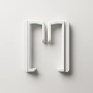 May include: A white, minimalist design element shaped like the letter "M". The object has a clean, modern aesthetic with rounded corners and a smooth surface. The design is set against a plain white background.