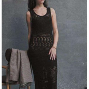 Puede incluir: Un vestido maxi de crochet negro con un patrón geométrico. El vestido tiene un escote redondo y es sin mangas.