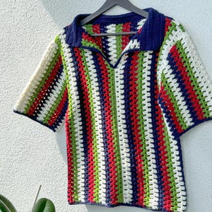 May include: A striped crochet top with a collared neckline. The top is made in a variety of colors, including white, red, green, and blue.