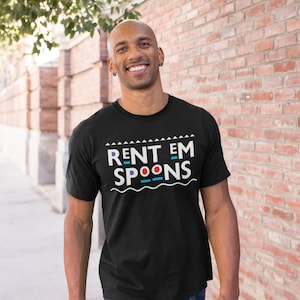 May include: Black t-shirt with the text "RENT EM SPOONS" in white, blue, and red. The shirt is worn by a person in blue jeans, standing in front of a brick wall and a pavement.