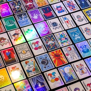 May include: A collection of colorful playing cards with various designs and illustrations. The cards are arranged in a grid pattern and have a holographic finish.