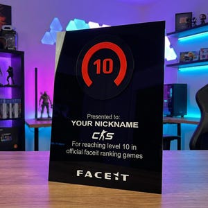 May include: A black acrylic award with a red circular design featuring the number 10. The text reads "Presented to: YOUR NICKNAME" and "For reaching level 10 in official faceit ranking games." The Faceit logo is at the bottom.