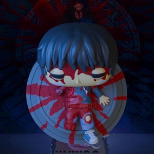 May include: A figurine of a character with blue hair and red paint, resembling blood. The figure stands on a grey circular base with red streaks. The name "JINWOO" is at the bottom, with "STUDI MADO" text on the side.