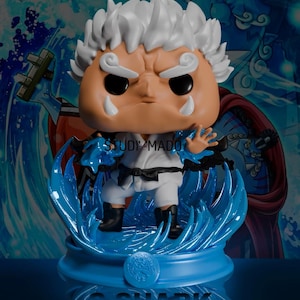 May include: A collectible figurine of a character with white hair and a stern expression, wearing a white outfit with a black belt. The figure is posed on a blue, wave-like base with the text "S-SHARK" at the bottom.