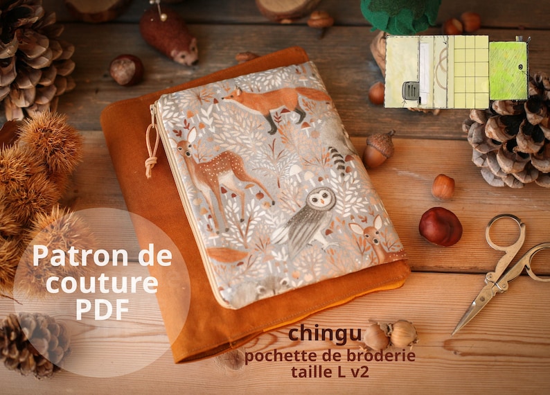 May include: A brown leather pouch with a zipper closure and a colorful fabric lining featuring a woodland animal print. The fabric lining has a pattern of deer, owls, foxes, and mushrooms. The pouch is labeled "chingu pochette de broderie taille L v2".