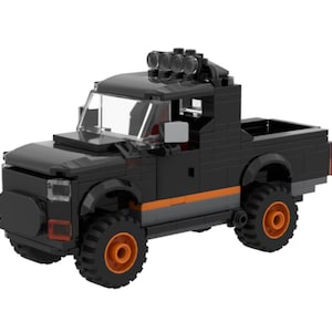 May include: Black toy pickup truck with orange and gray accents. The truck has large off-road tires and a light bar on the roof. The truck is made of interlocking plastic bricks.