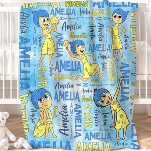 May include: A blue and yellow fleece blanket with a repeating pattern of the character Joy from the movie Inside Out. The character is holding a yellow star and the name Amelia is repeated throughout the blanket.