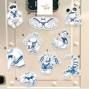 May include: A white ceramic mug with a black handle and the text "But First, Coffee" in a black, bold font. The mug is sitting on a wooden surface. The mug is approximately 4 inches tall.