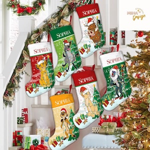 May include: Christmas stockings featuring characters from The Lion King, including Simba, Timon, Pumbaa, and others, each wearing a Santa hat. The stockings are red, green, and white, with the name "Sophia" embroidered on the cuff.