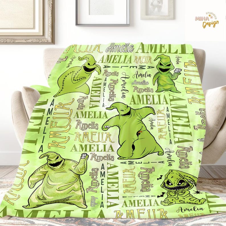 May include: A lime green blanket featuring cartoon characters and the name "Amelia" in various fonts. The blanket has multiple images of a green character in different poses. The background is a lighter shade of green.