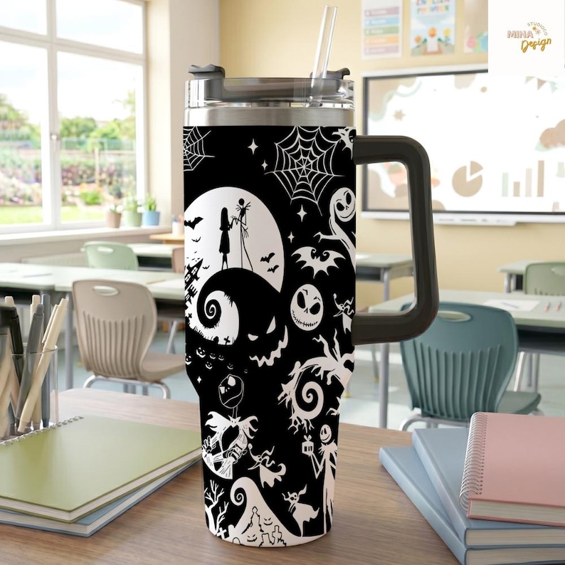 May include: A black and white stainless steel tumbler with a handle and a clear straw, featuring a repeating pattern of silhouettes including a moon, a couple, spiderwebs, bats, and various skeletal characters on a dark background.