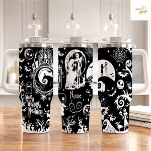 May include: Three stainless steel tumblers with handles and clear lids, featuring a black and white pattern of characters and scenes from a movie. The design includes spiderwebs, trees, and the text "What a Wonderful Nightmare" and "Name".