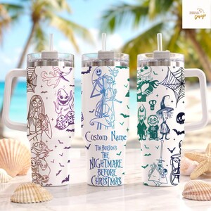 May include: Three white stainless steel tumblers with handles and straws, featuring line art of characters from The Nightmare Before Christmas. The center tumbler displays the text Custom Name and Tim Burton's The Nightmare Before Christmas.