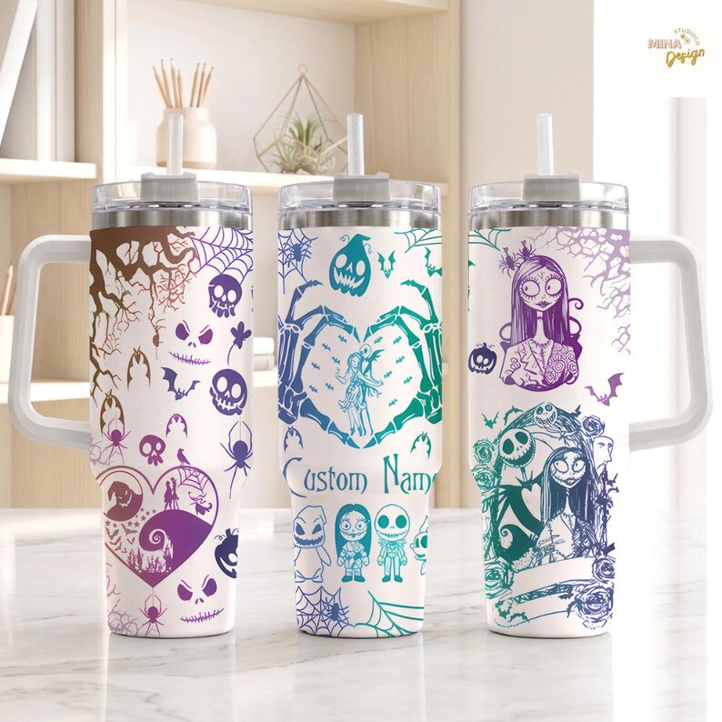 May include: Three white stainless steel tumblers with handles and straws, each featuring a wrap-around print of characters and motifs from The Nightmare Before Christmas in purple, teal, and brown, with the text Custom Name on the center tumbler.