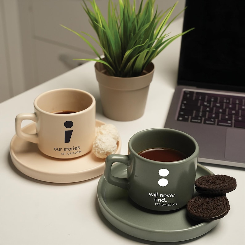 a cup of coffee next to a laptop on a desk