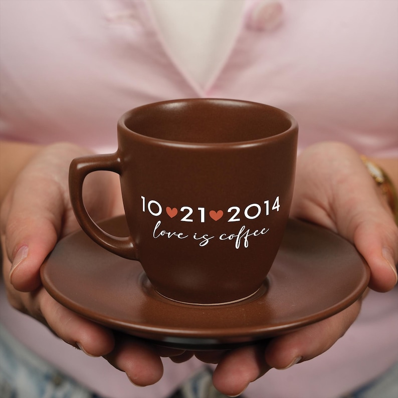 a person holding a coffee cup with a date on it