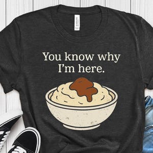 Puede incluir: Camiseta gris oscuro con el texto "You know why I'm here." encima de una imagen de dibujos animados de puré de patatas y salsa en un cuenco blanco. La camiseta está etiquetada como "H. DARK GREY".