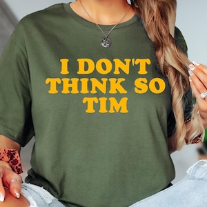May include: Military green t-shirt with the text "I DON'T THINK SO TIM" in yellow. The shirt is a crew neck style and is made of a soft material. The words "MILITARY GREEN" are printed at the bottom of the image.